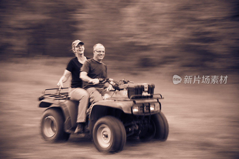 Man and Woman Couple Driving Four Wheeler All Terrain Off Road Vehicle in Motion